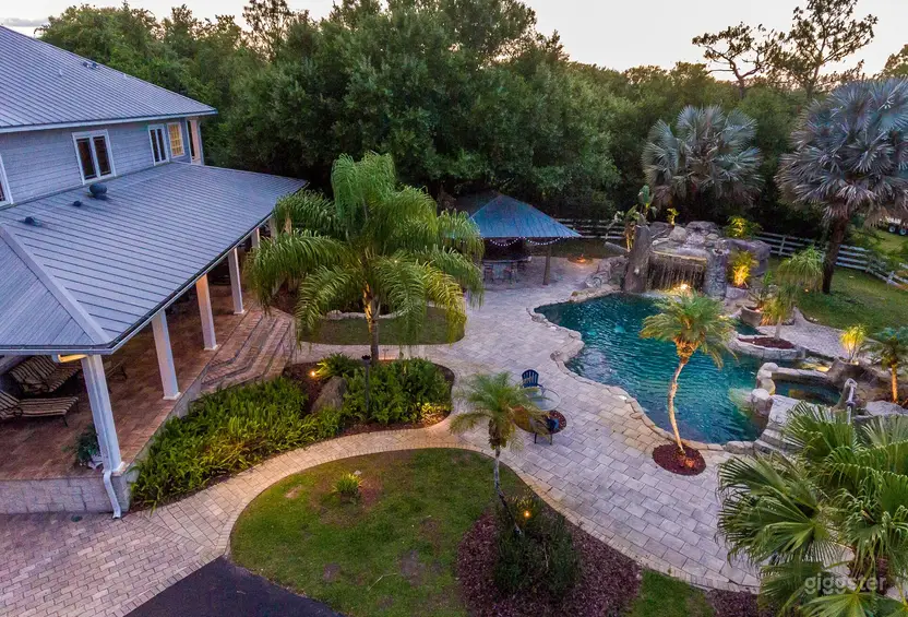 Aerial view of Southern Plantation Oasis pool, grotto, and lush tropical grounds at dusk